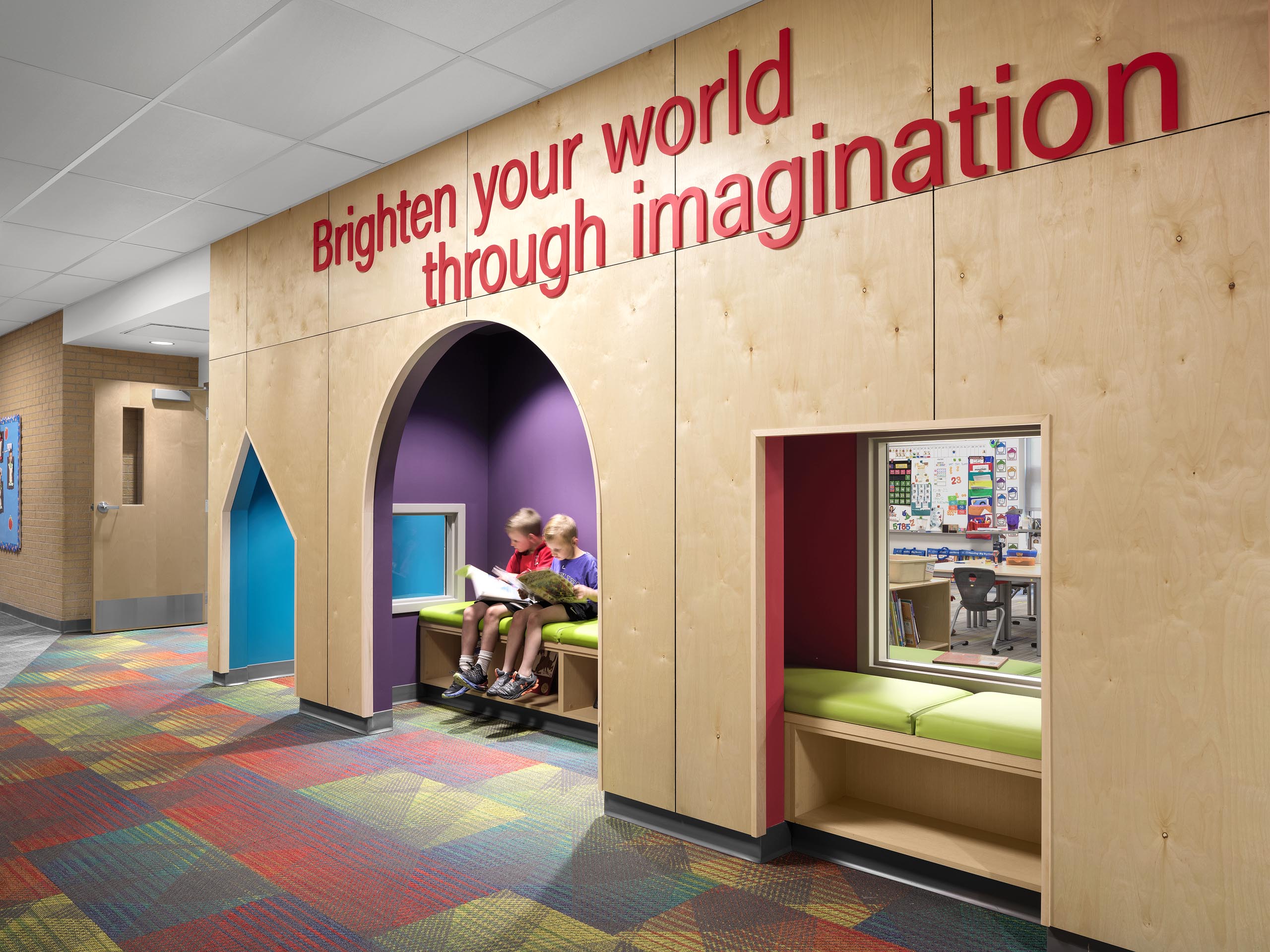 Architectural photography by Warren Diggles. Eaton Elementary students reading in colorful nook built into existing hallway. K-12 remodel project by RB+B Architects and FCI Constructors.