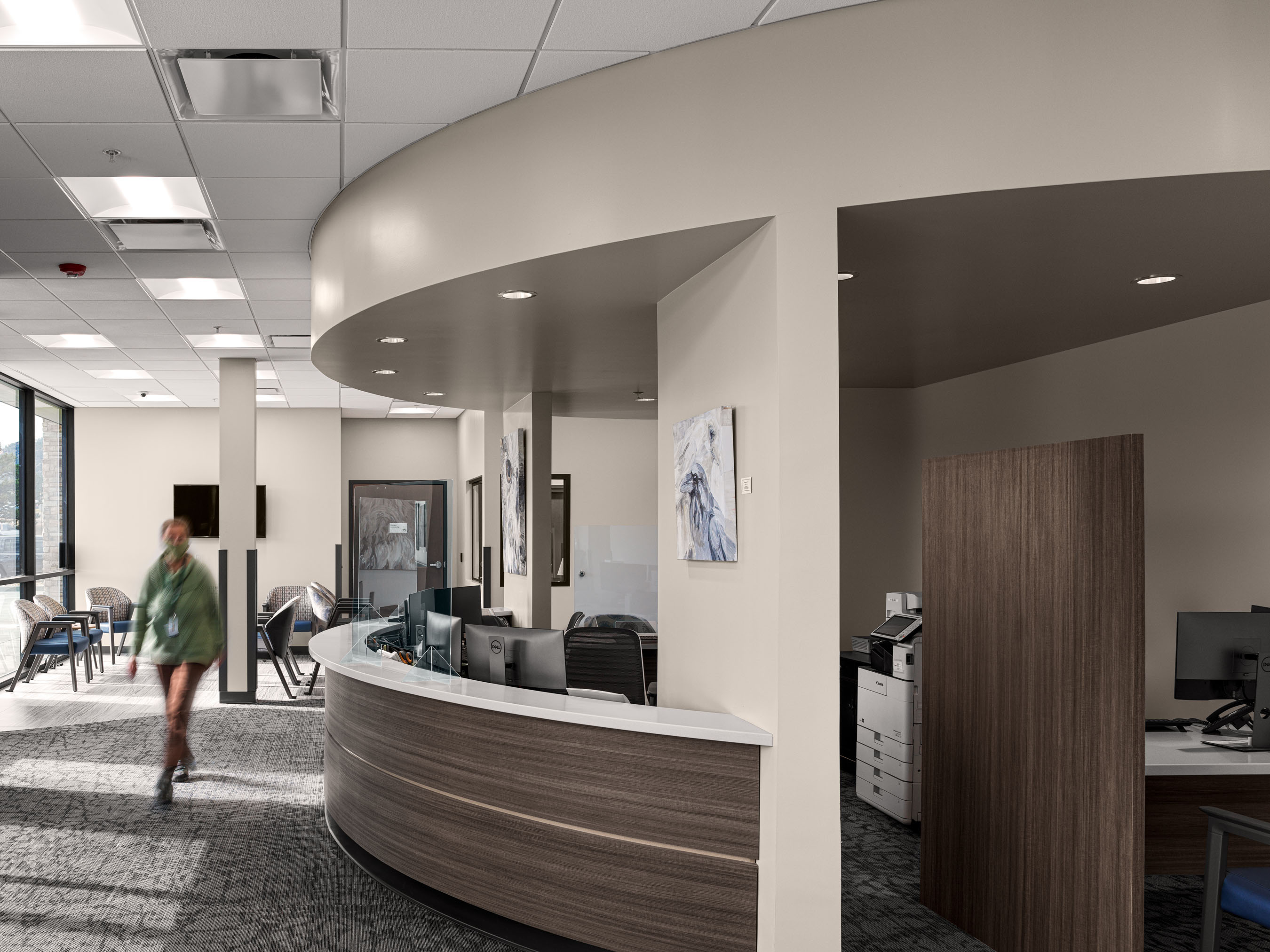 Commercial interior photography by Warren Diggles. Receptionist walking through lobby at Estes Park Health Urgent Care. Project by Bas1s Architecture and Saunders Heath Construction.